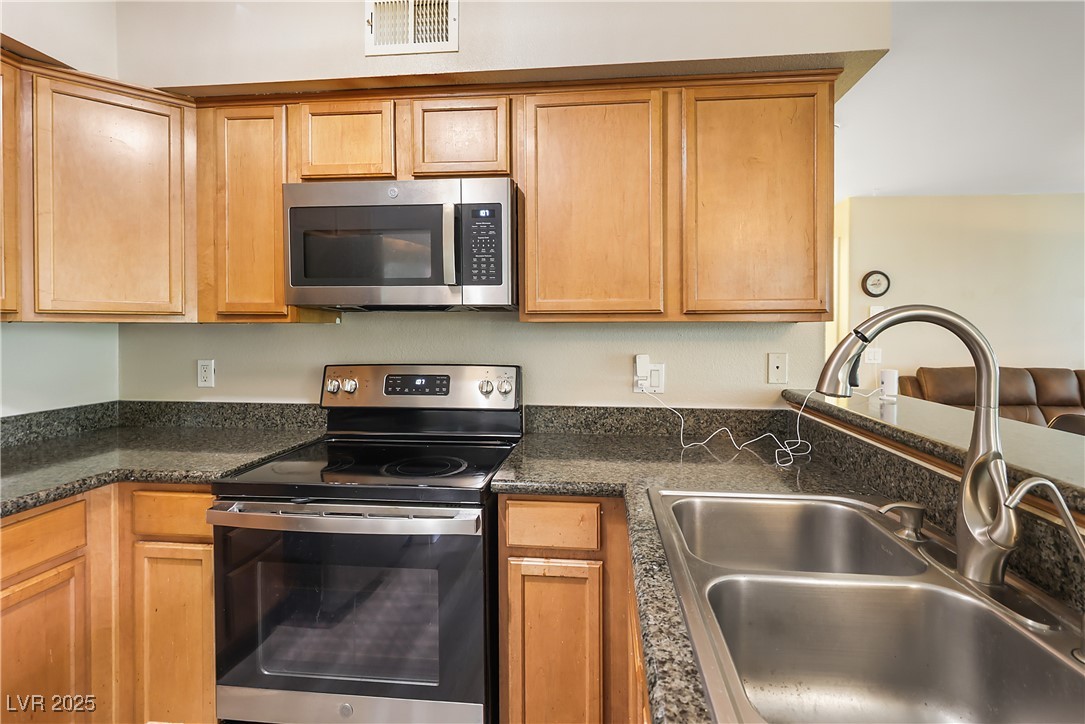 3145 East Flamingo Road, Unit 1123 Las Vegas, NV 89121 - Photo 11 of 30 Kitchen featuring stainless steel appliances and dark stone counters