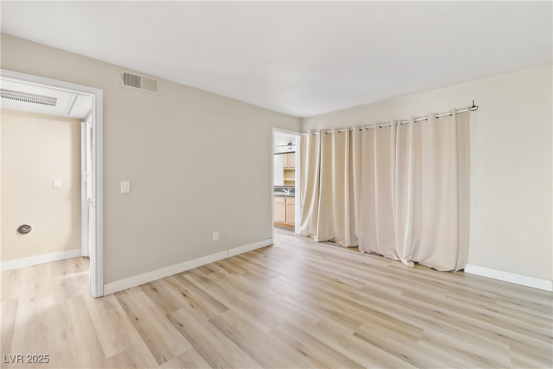 3145 East Flamingo Road, Unit 1123 Las Vegas, NV 89121 - Photo 15 of 30 Empty room featuring baseboards and light wood-type flooring