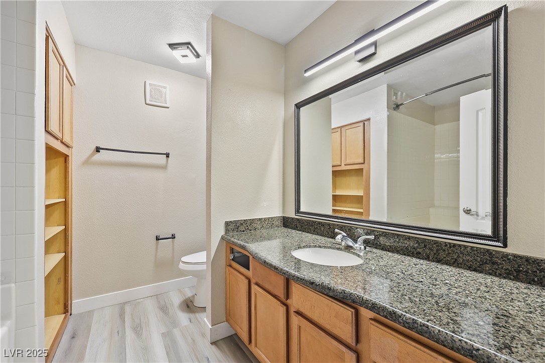 3145 East Flamingo Road, Unit 1123 Las Vegas, NV 89121 - Photo 16 of 30 Full bathroom featuring vanity, a shower, wood finished floors, and a textured ceiling