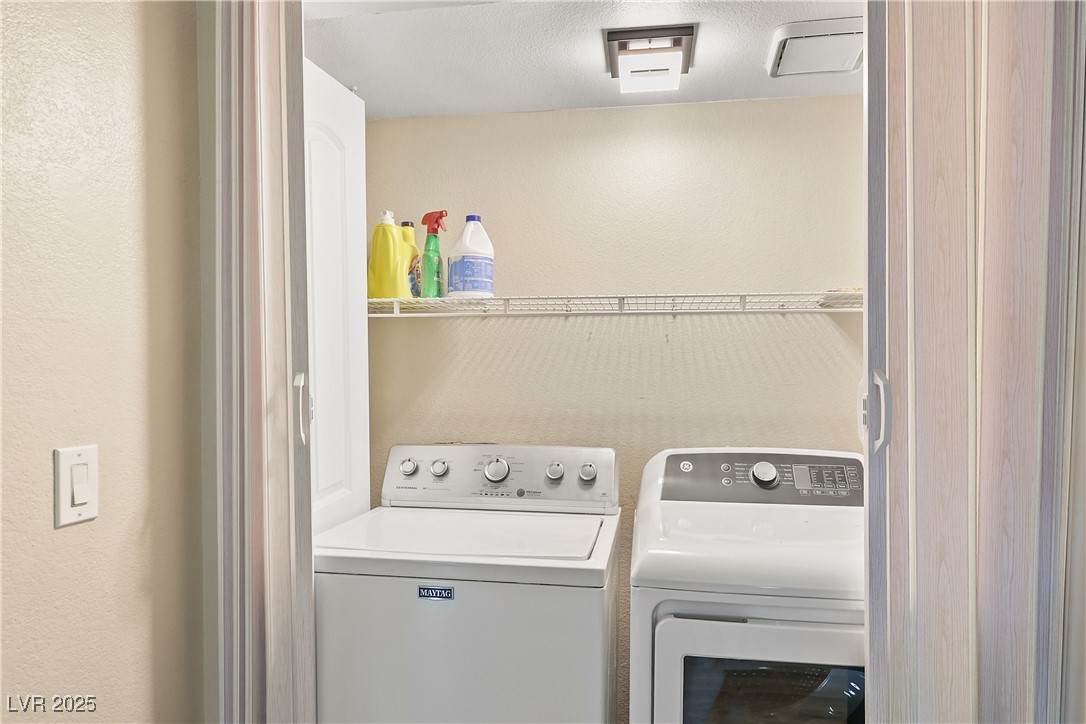 3145 East Flamingo Road, Unit 1123 Las Vegas, NV 89121 - Photo 21 of 30 Laundry room with washing machine and dryer and a textured wall