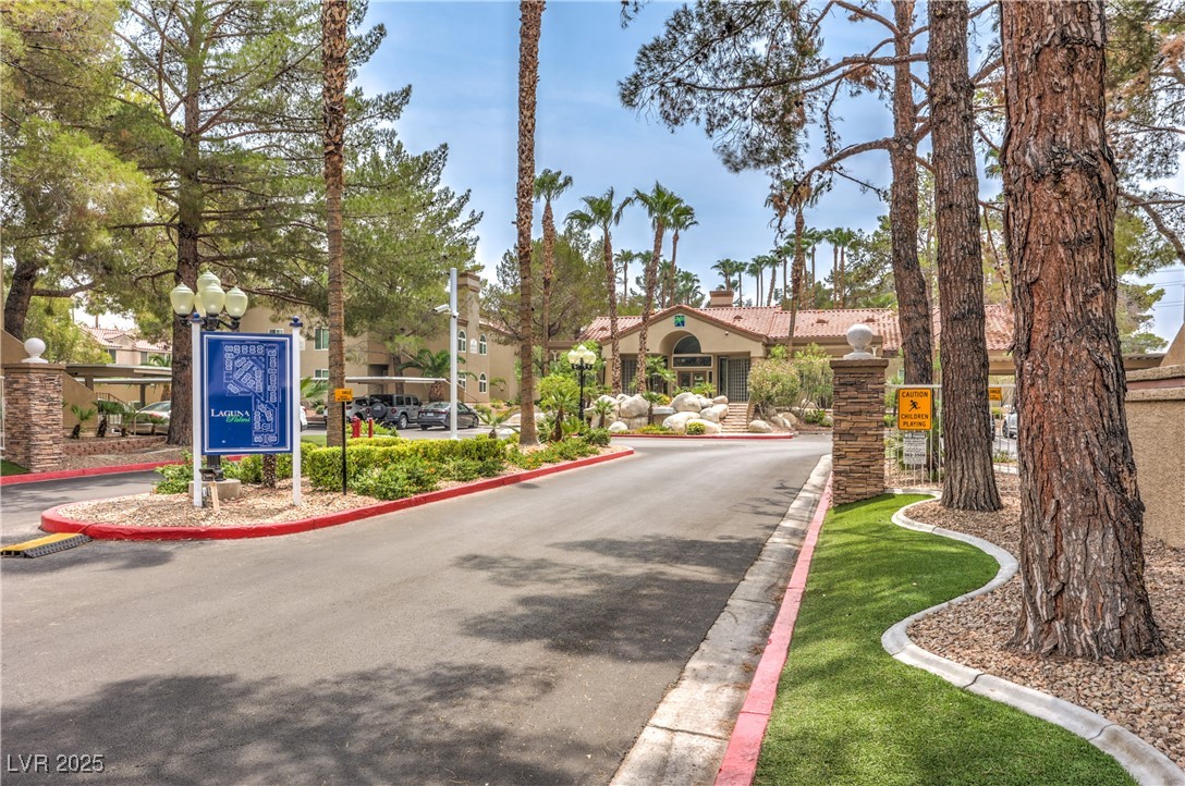 3145 East Flamingo Road, Unit 1123 Las Vegas, NV 89121 - Photo 28 of 30 View of asphalt road with curbs, street lighting, and a gated entry