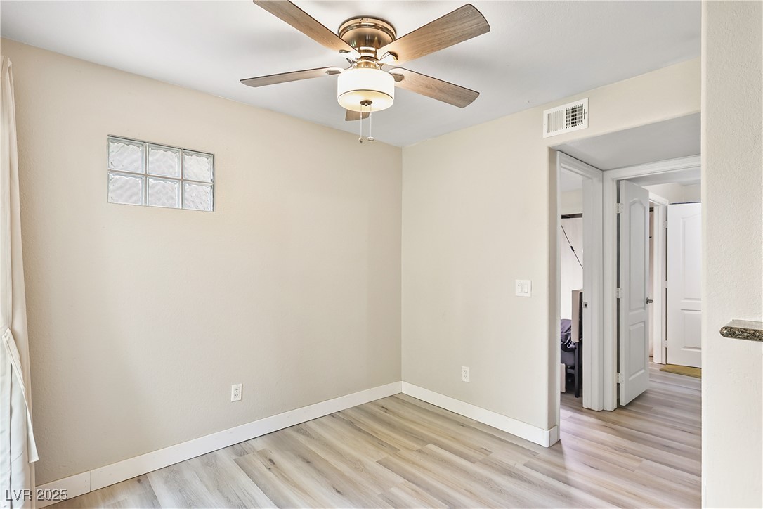 3145 East Flamingo Road, Unit 1123 Las Vegas, NV 89121 - Photo 8 of 30 Unfurnished bedroom with light wood finished floors and a ceiling fan