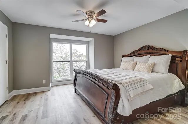 a bedroom with a large bed and a ceiling fan