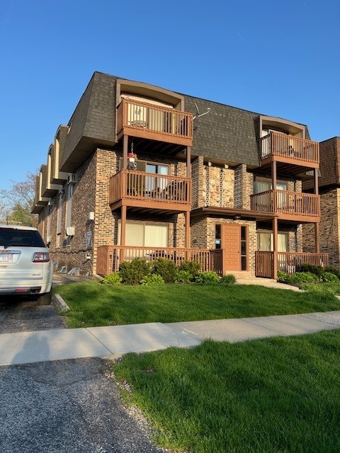 14747 Kenton Avenue, Unit 2A Midlothian, IL 60445 - Photo 2 of 16 a front view of a residential apartment building with a yard