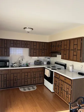 a kitchen with stainless steel appliances granite countertop a stove a sink and a white cabinets