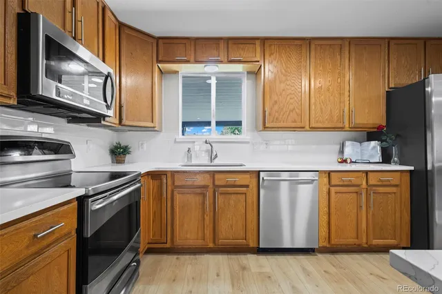 a kitchen with stainless steel appliances granite countertop a sink stove and microwave