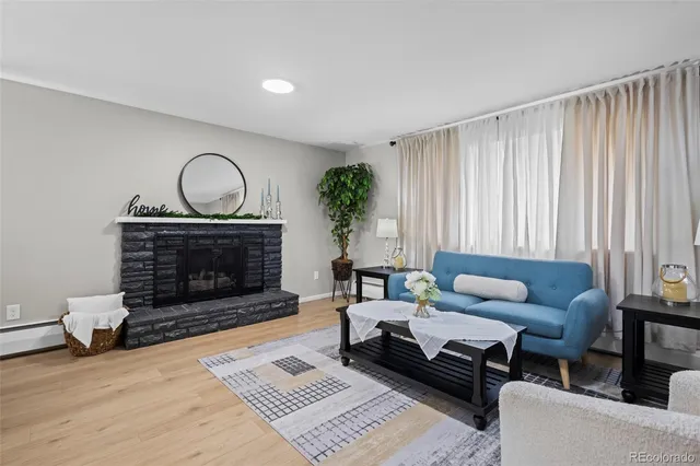 a living room with furniture a fireplace a rug and a window