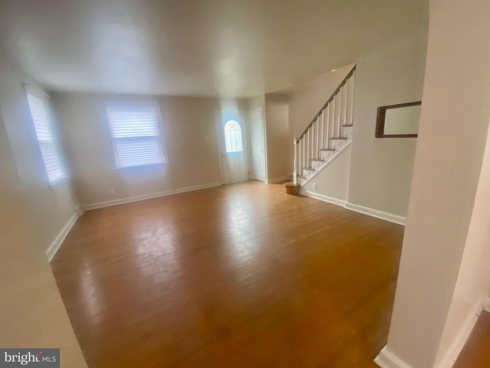 4019 Hellerman Street Philadelphia, PA 19135 - Photo 3 of 12 a view of an empty room with wooden floor and a window