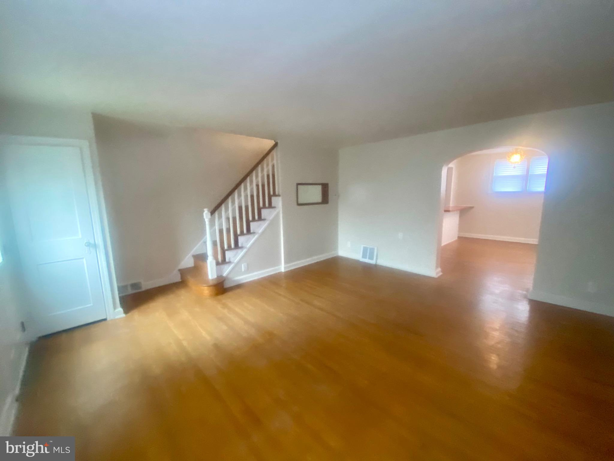 4019 Hellerman Street Philadelphia, PA 19135 - Photo 6 of 12 a view of an empty room with wooden floor and windows