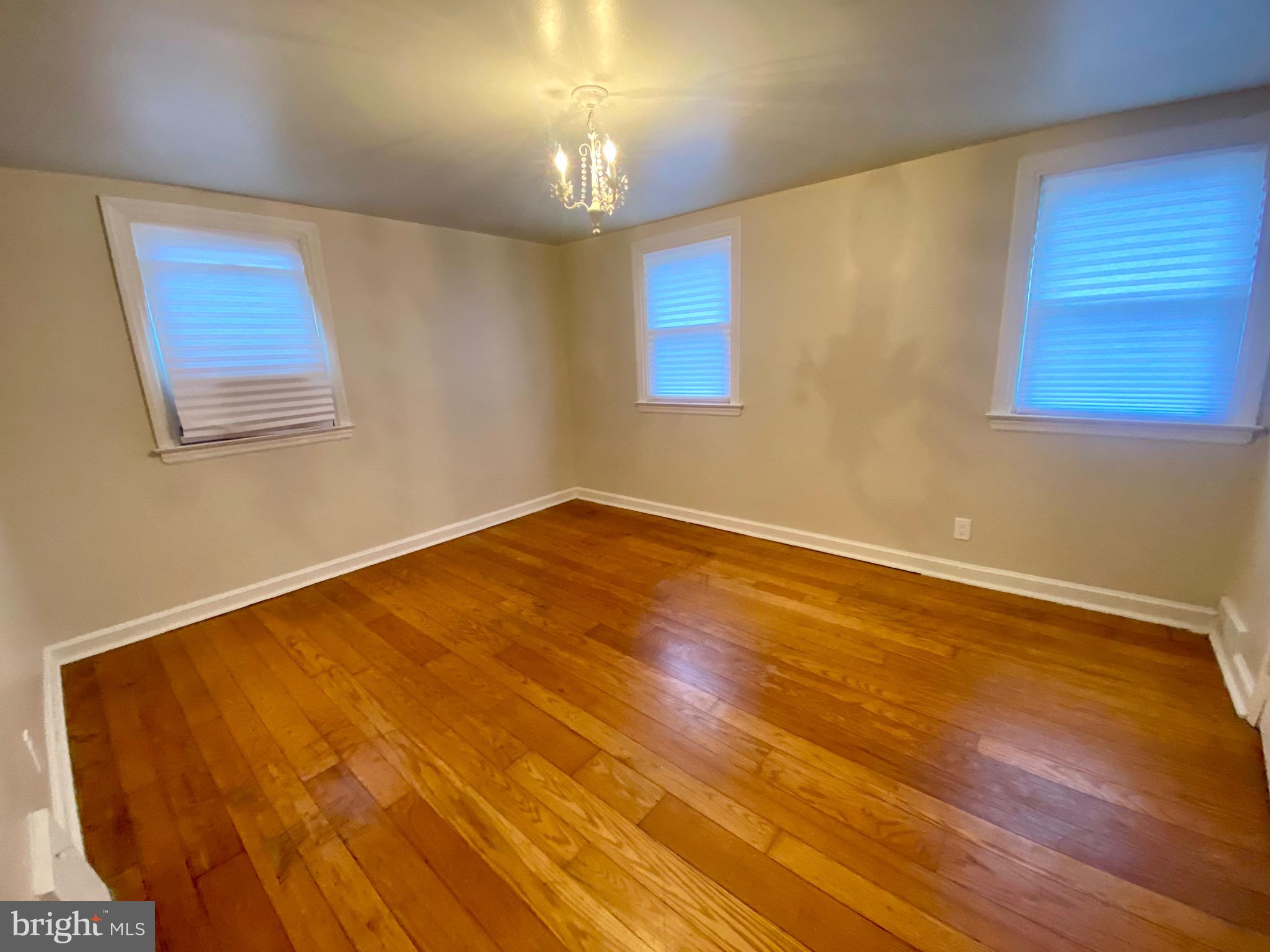 4019 Hellerman Street Philadelphia, PA 19135 - Photo 8 of 12 a view of an empty room with wooden floor and a chandelier