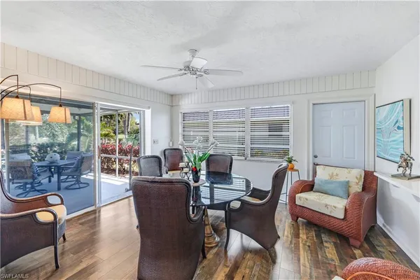 a dining room with furniture large windows and a chandelier