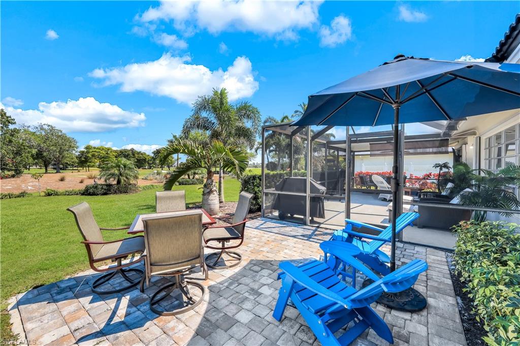 1382 Jamaica Road Marco Island, FL 34145 - Photo 21 of 27 a view of a patio with a dining table and chairs under an umbrella