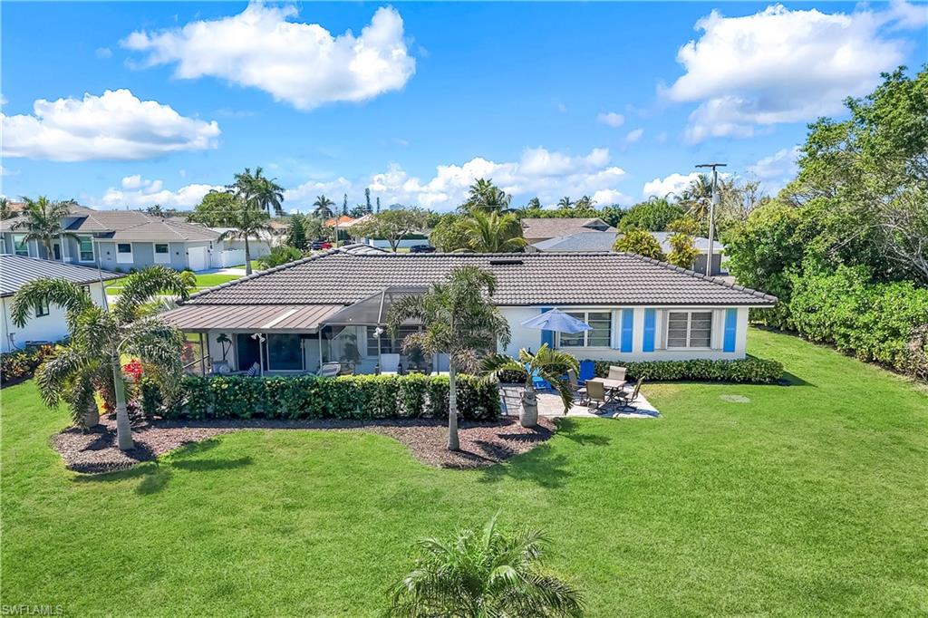 1382 Jamaica Road Marco Island, FL 34145 - Photo 25 of 27 a view of a house with a backyard porch and sitting area