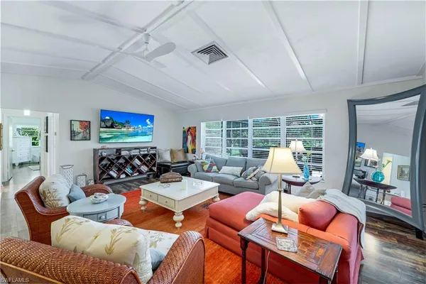 a living room with furniture a rug and a floor to ceiling window