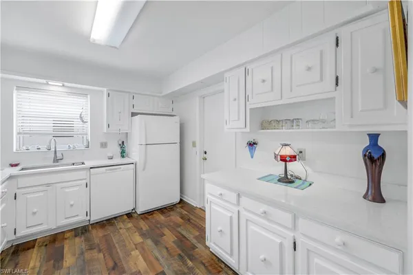 a kitchen with white cabinets and sink