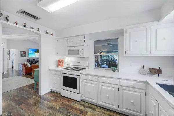 a kitchen with white cabinets and white appliances