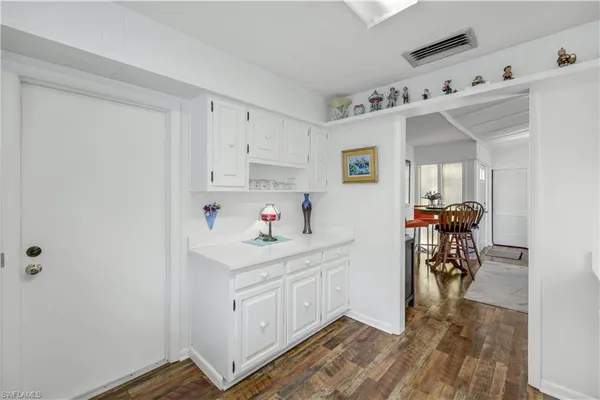 a view of utility room and bedroom with wooden floor