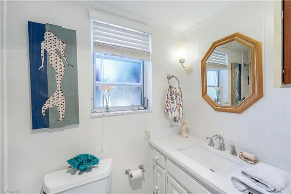 a bathroom with a sink mirror and vanity