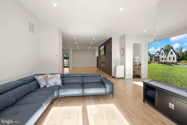 a kitchen with stainless steel appliances kitchen island granite countertop a stove top oven a sink a dining table chairs and view living room