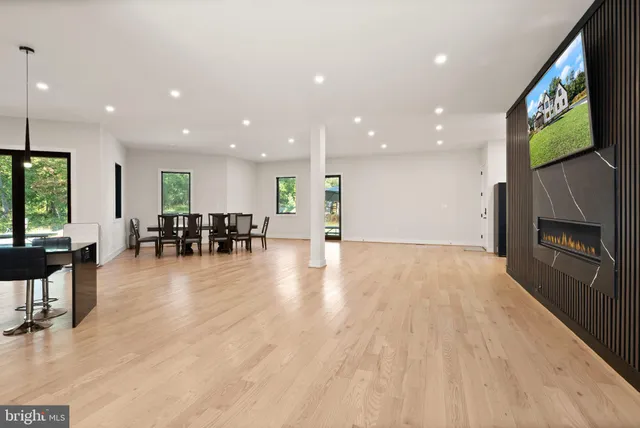 a kitchen with stainless steel appliances kitchen island granite countertop a table chairs in it and wooden floors