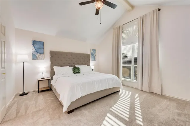 a bedroom with a bed lamp and window