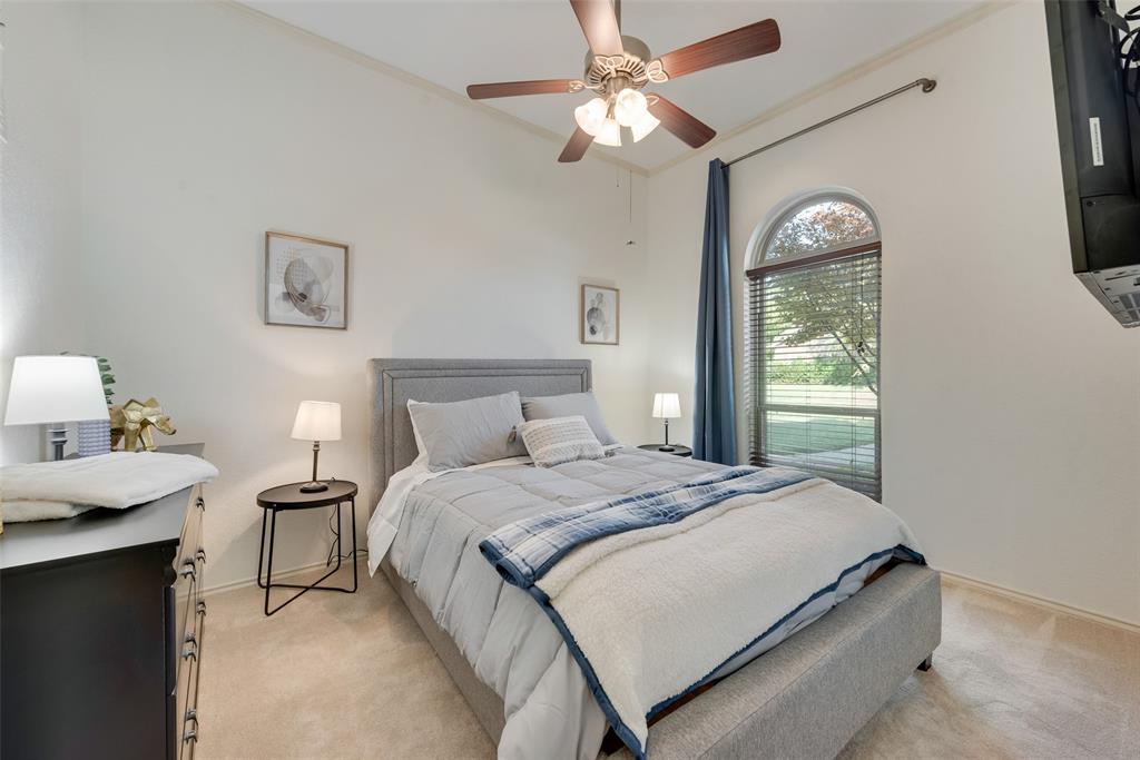 4027 Red Maple Drive Carrollton, TX 75007 - Photo 19 of 35 a bedroom with a bed and a chandelier