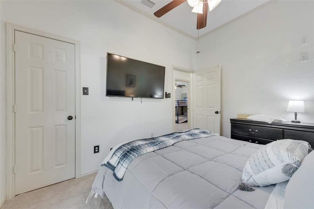 4027 Red Maple Drive Carrollton, TX 75007 - Photo 20 of 35 a bedroom with a bed and a flat screen tv