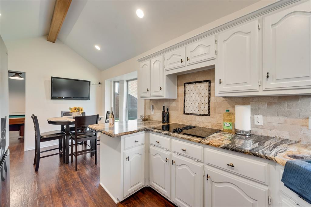 4027 Red Maple Drive Carrollton, TX 75007 - Photo 3 of 35 a open kitchen with granite countertop a stove a sink a dining table and chairs with wooden floor