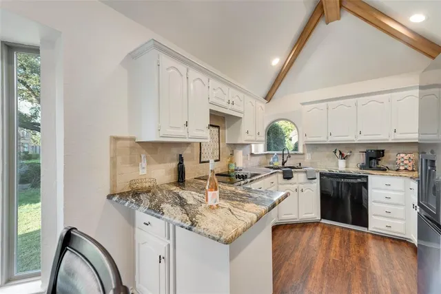 a kitchen with granite countertop a sink stainless steel appliances and cabinets
