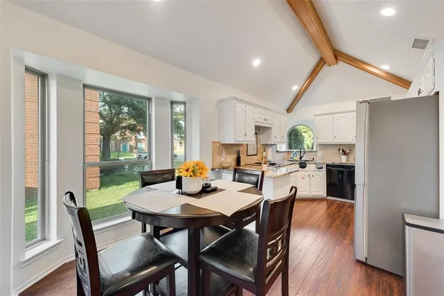 a view of a dining room and livingroom with furniture wooden floor and a rug