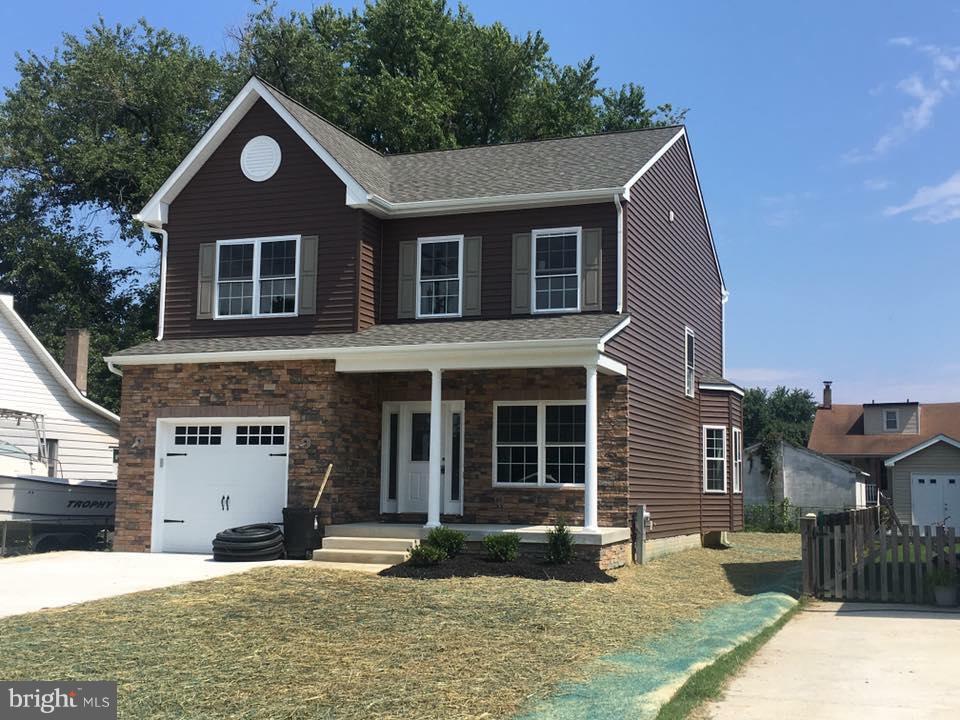 7702 Bay Front Road Baltimore, MD 21219 - Photo 1 of 2 a front view of a house with yard and parking