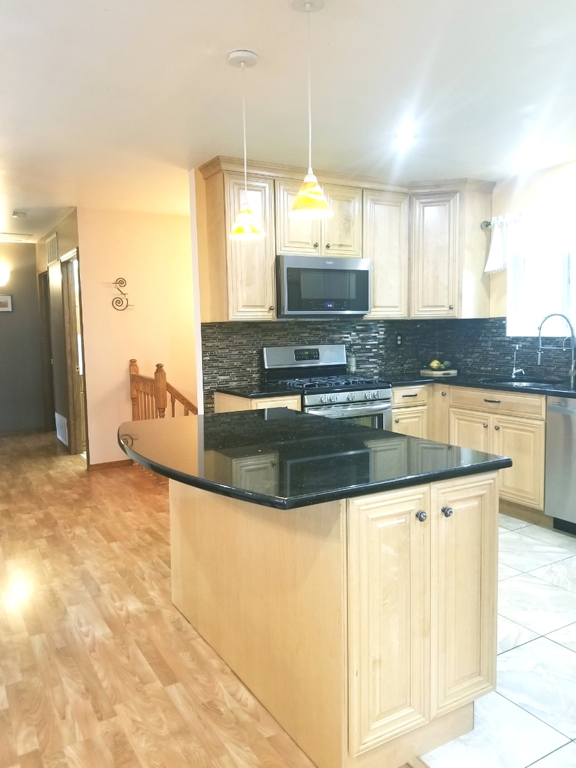 137 South Pinecrest Road Bolingbrook, IL 60440 - Photo 8 of 25 a kitchen with stainless steel appliances granite countertop a sink and a stove