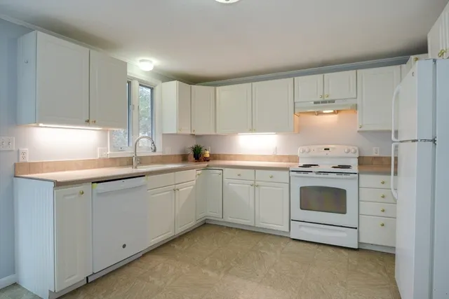 a kitchen that has a lot of cabinets in it with a dining table and chairs