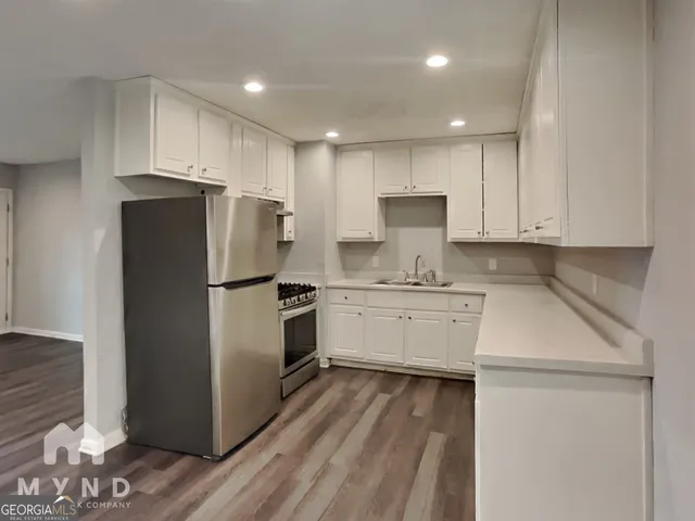 a kitchen with a refrigerator sink and cabinets