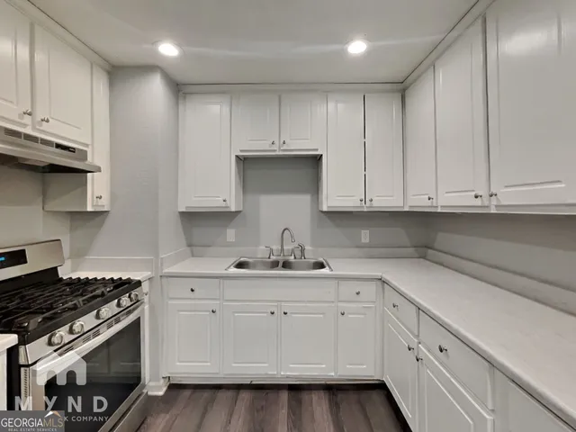 a kitchen with white cabinets and appliances