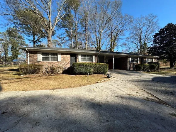 a front view of house with yard and trees around