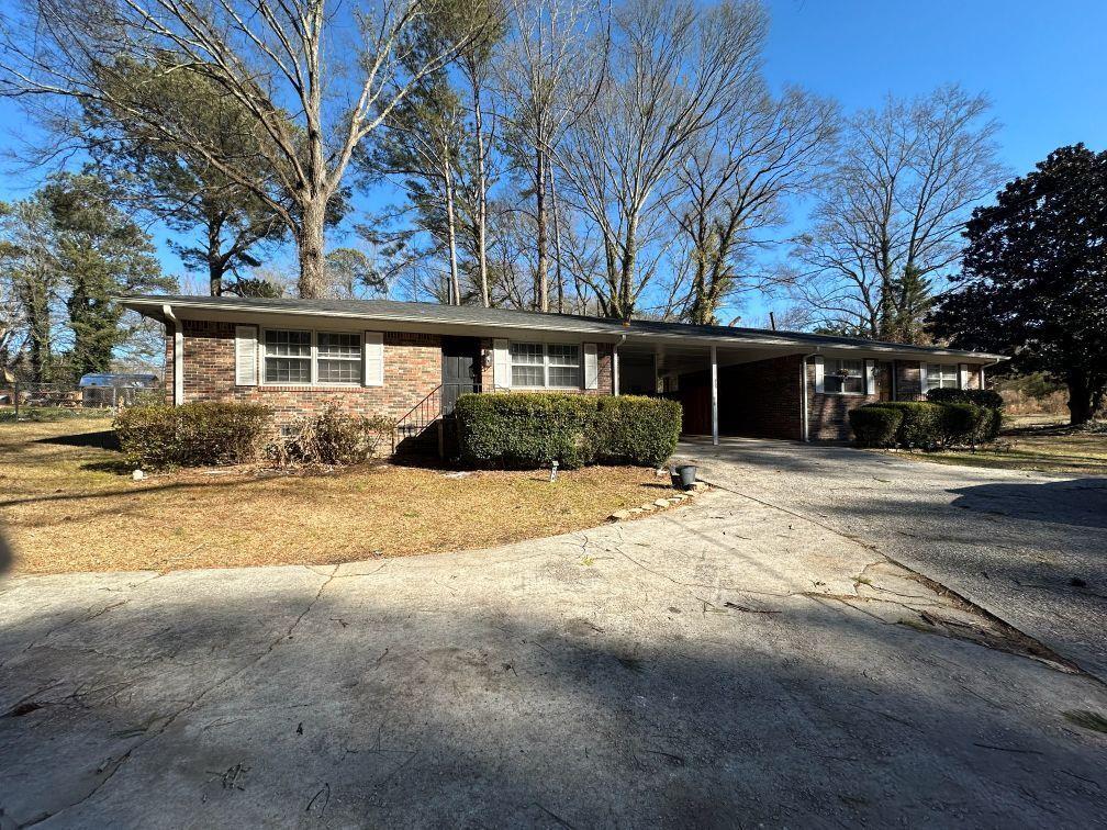 a front view of house with yard and trees around