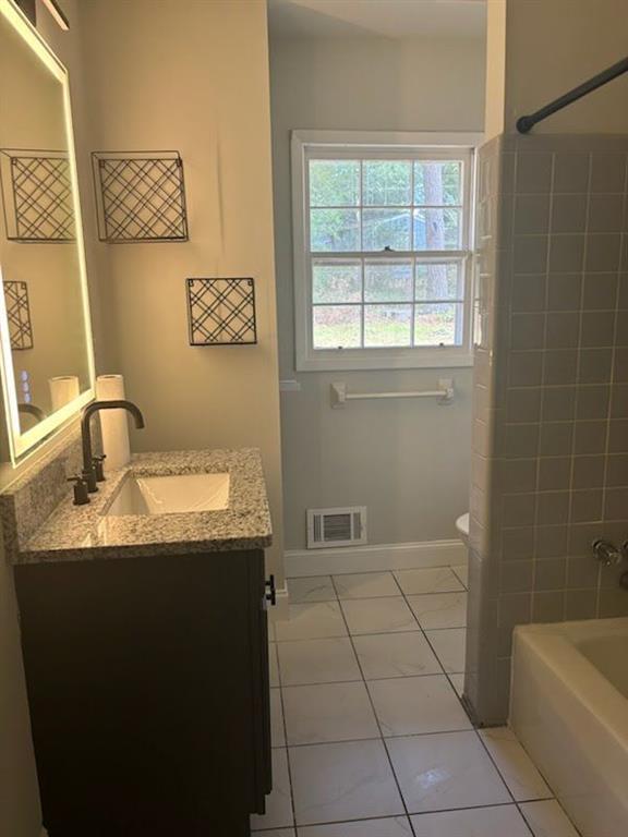 616 Fayetteville Road Jonesboro, GA 30236 - Photo 6 of 14 a bathroom with a granite countertop sink a toilet and bathtub
