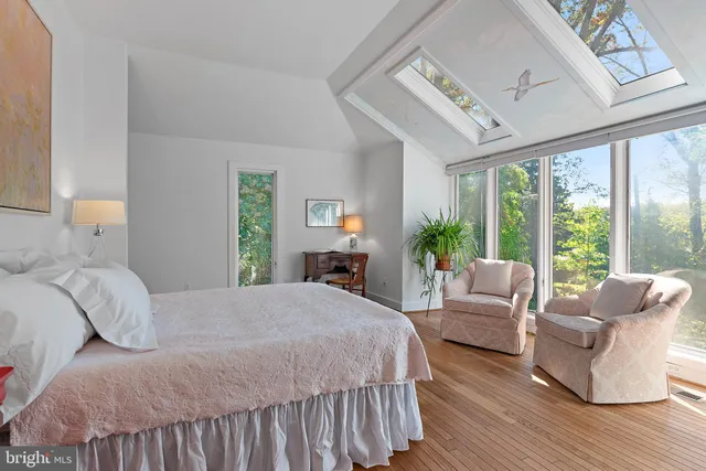 a bedroom with a large bed couch and a large window