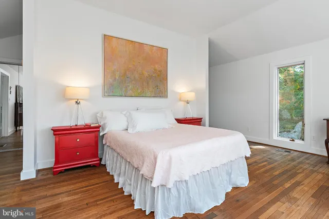 a bedroom with bed and wooden floor