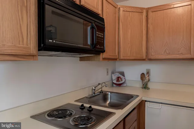 a kitchen with a sink a stove and cabinets