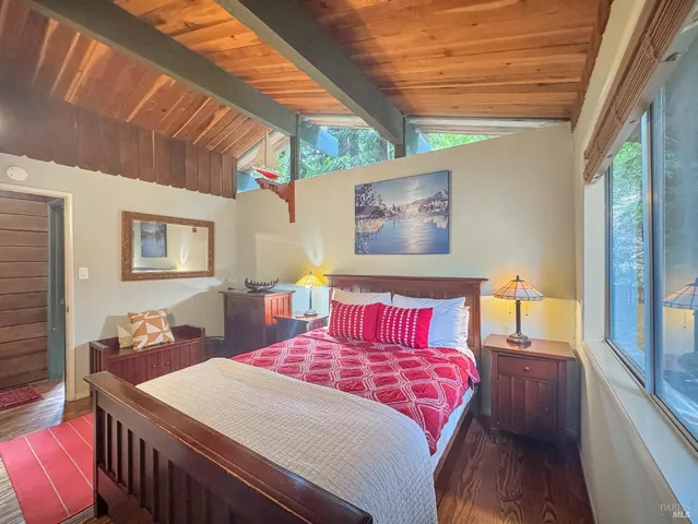 a bedroom with a bed a dresser next to a window