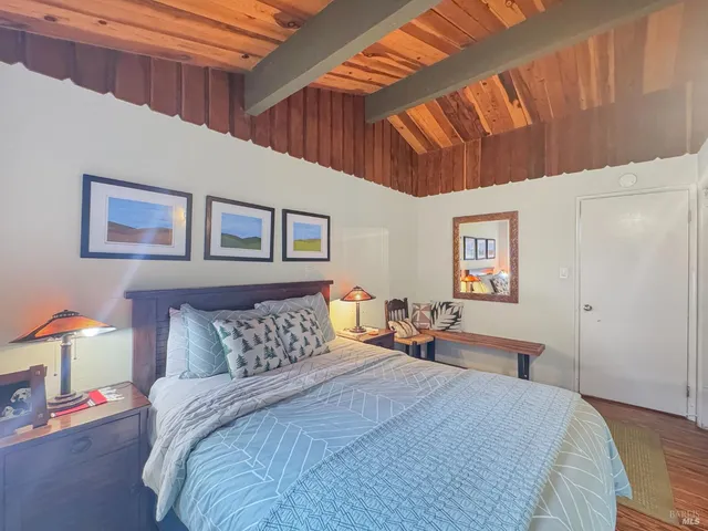 a bedroom with bed and wooden floor