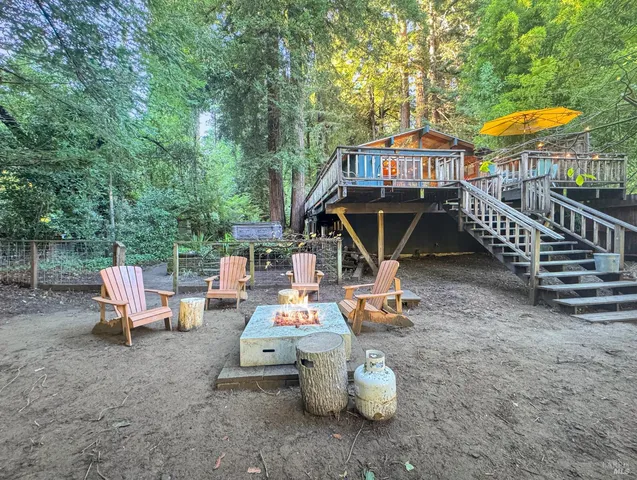 a view of backyard with a table and chairs under an umbrella