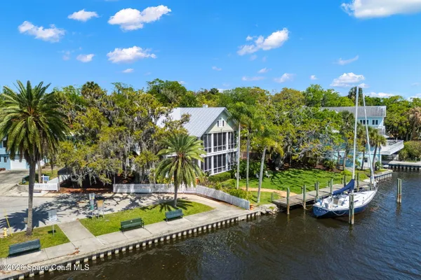 a view of a house with a large window and flower plants