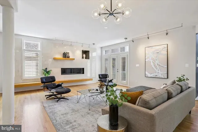 a living room with furniture a rug and a floor to ceiling window