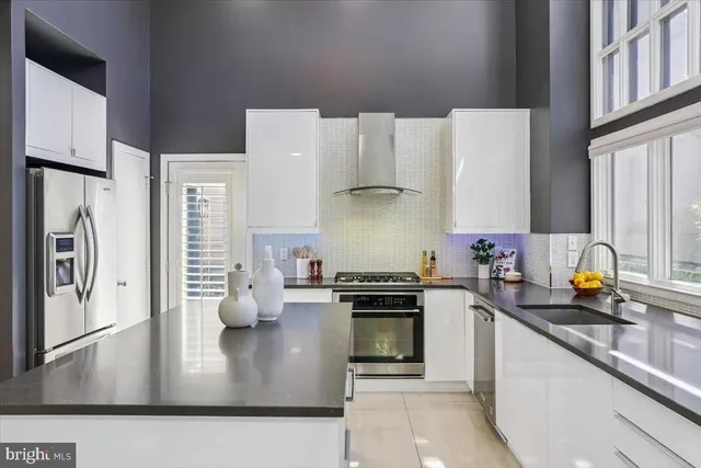 a kitchen with a sink window and chairs