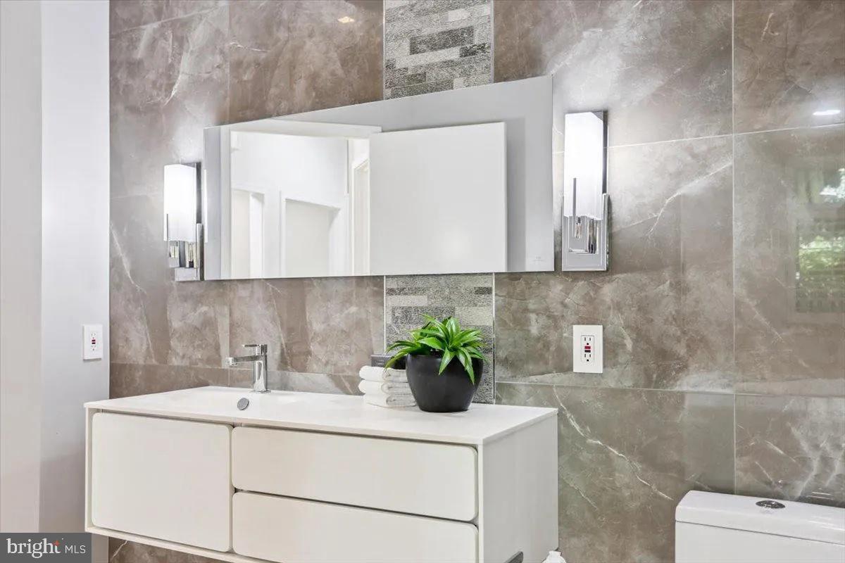 1460 Waterfront Road Reston, VA 20194 - Photo 26 of 59 a bathroom with a sink a toilet and mirror