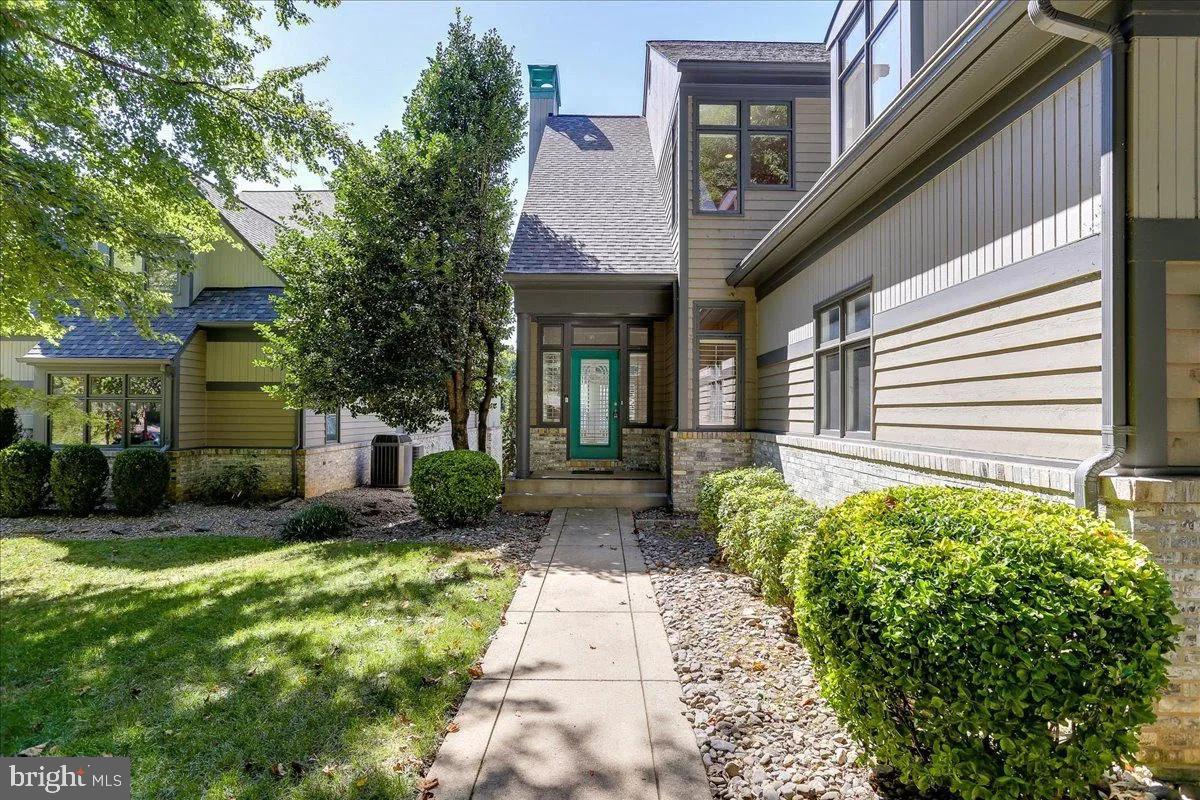 1460 Waterfront Road Reston, VA 20194 - Photo 8 of 59 a view of a brick house with a yard plants and a lawn chairs