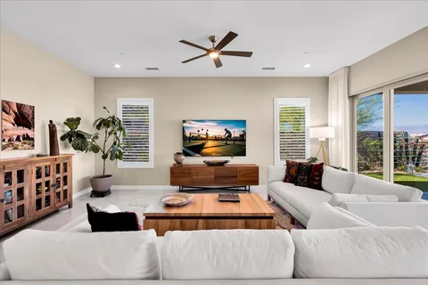 a living room with furniture kitchen view and a potted plant